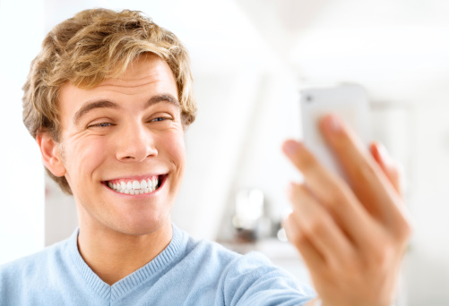 young adult male talking a smiling selfie
