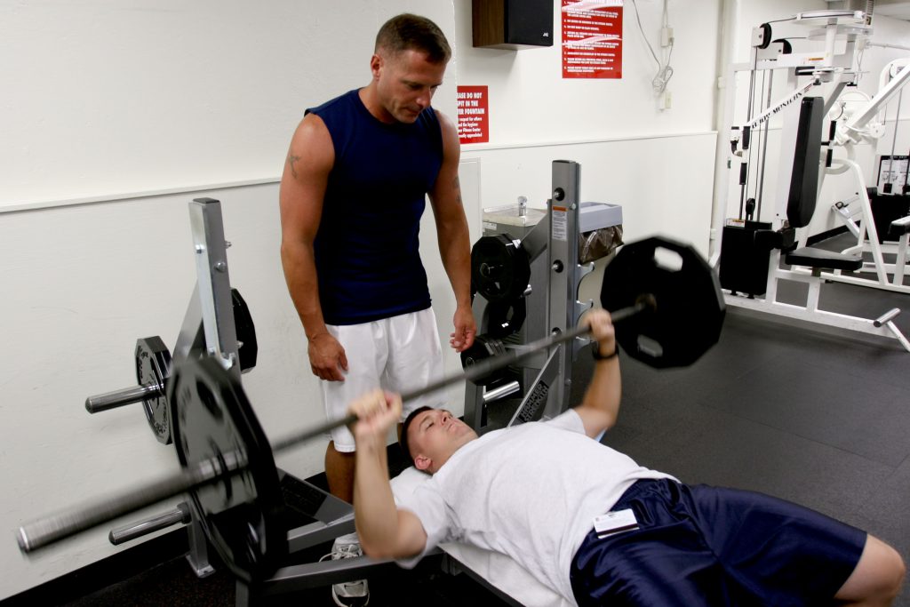 CAMP H.M. SMITH, Hawaii - Staff Sgt. Brett Garmon, G-4 air staff noncommissioned officer, U.S. Marine Corps Forces, Pacific, utilizes the bench press and weights, while safely being spotted by Master Sgt. Bill Atwater, G-4 maintenance management chief, MARFORPAC at the Semper Fit Center here.