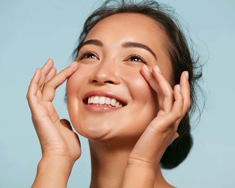smiling woman gently touching her face